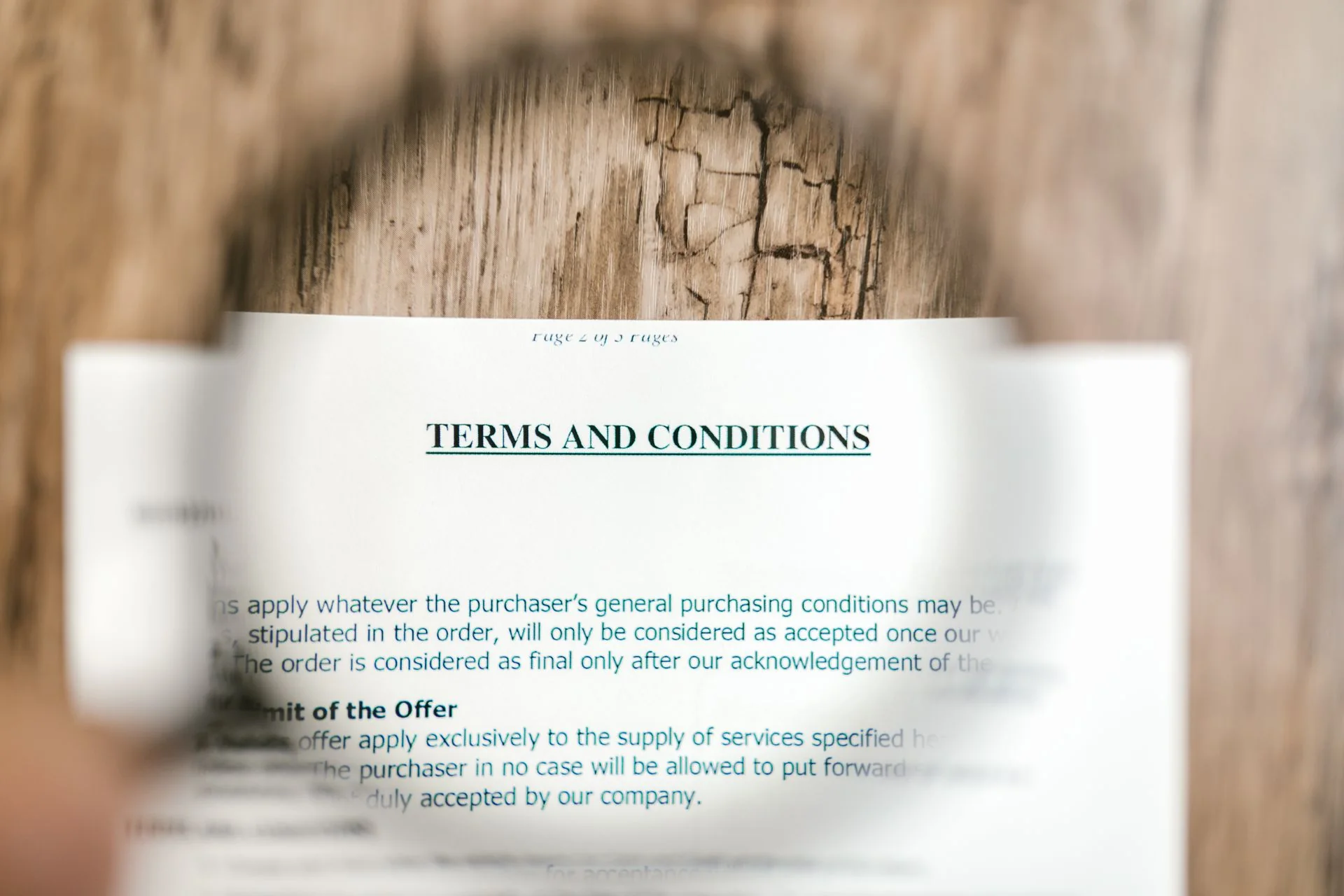 A magnifying glass held over a printed page headed Terms and Conditions.